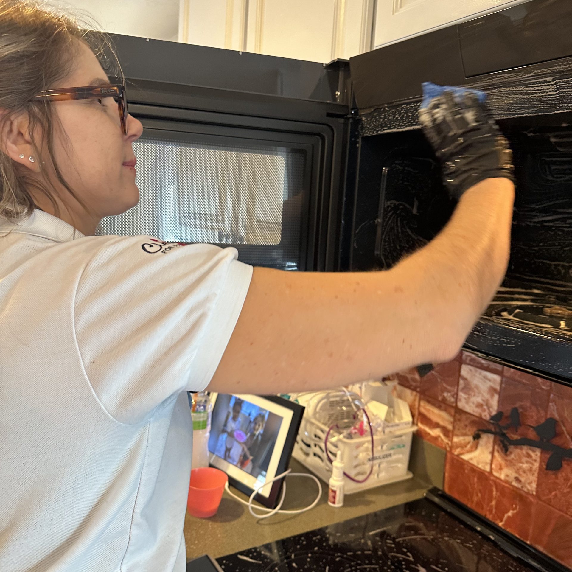 Deep-cleaned modern bathroom vanity with a smudge-free dark quartz countertop, polished matte black faucet, and a streak-free wood-framed mirror.