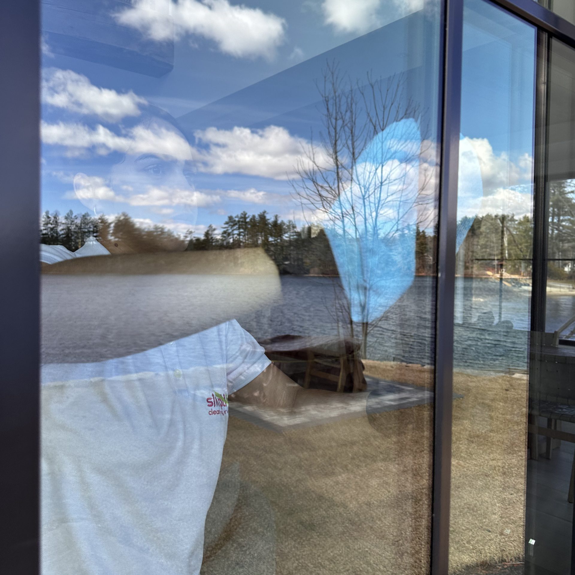 Cleaner performing streak-free window cleaning on large glass sliding doors.