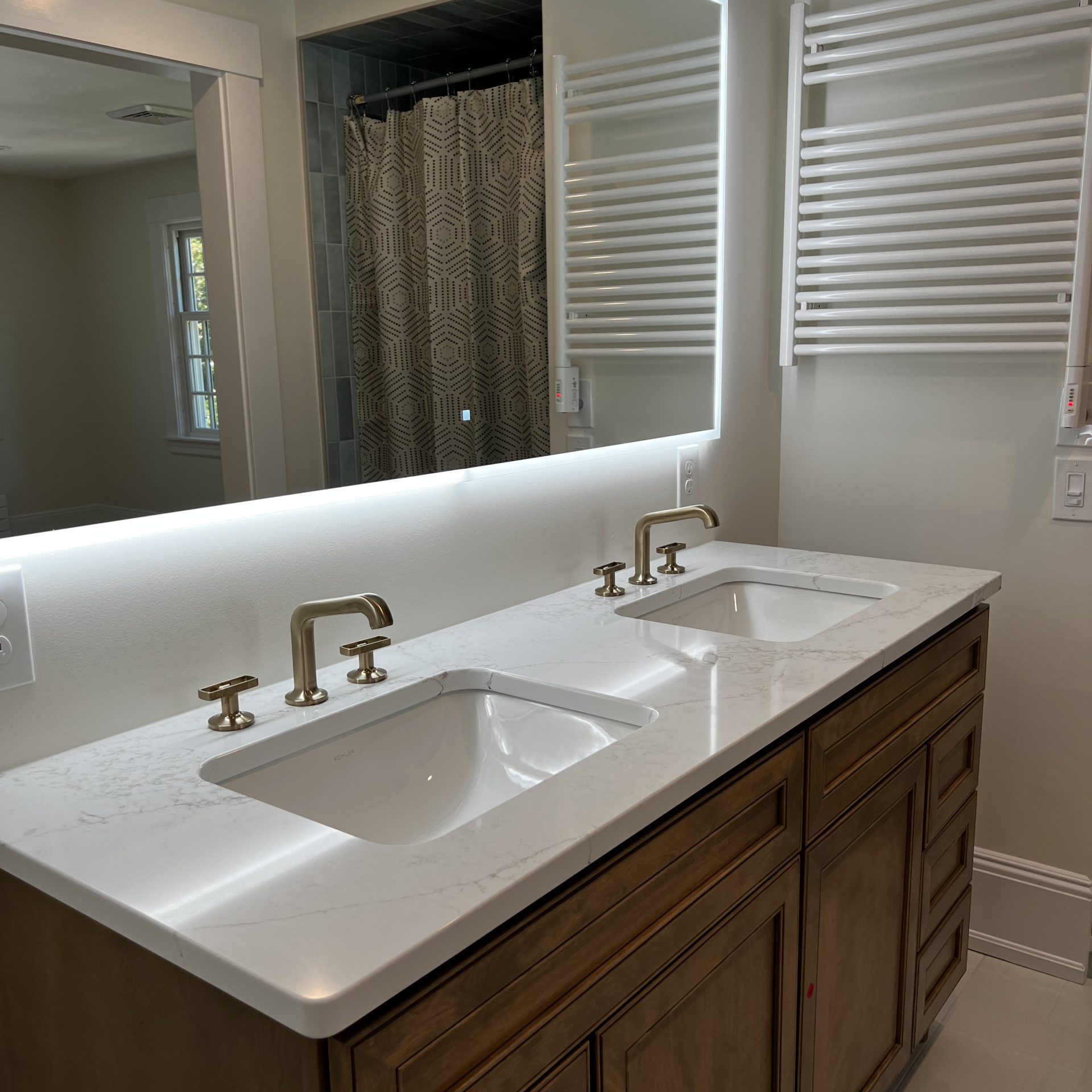 Professional deep cleaning of a luxury master bathroom featuring a polished double vanity, sparkling white marble countertops, and streak-free mirrors with integrated LED lighting.