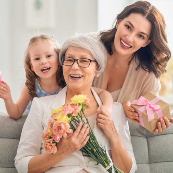 Maid Service Gift Cards A woman and her young daughter present a grandmother with flowers and a gift card for maid services.